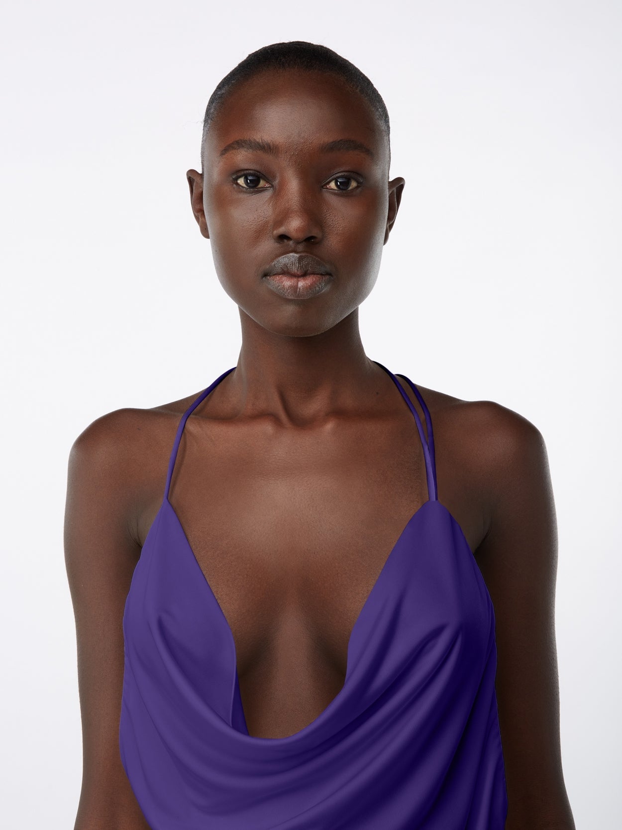 close up of model wearing purple halter neck mini dress with  open back