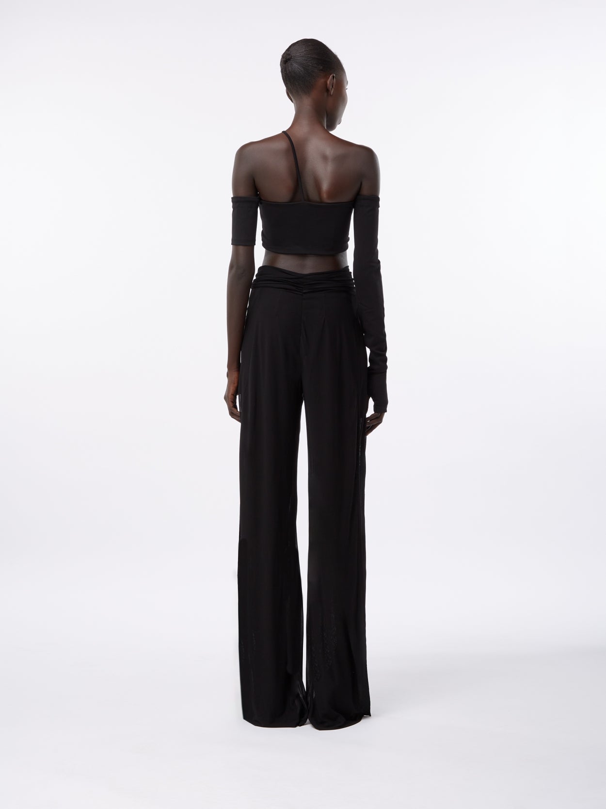 model wearing black draped trousers with twist detaill